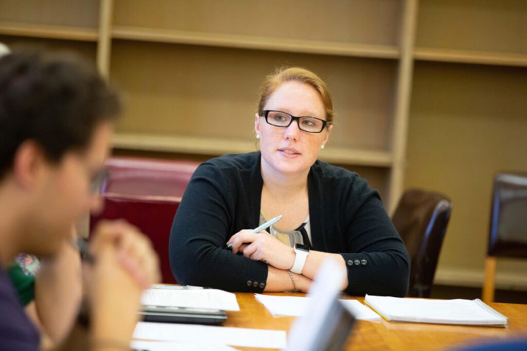 Woman sitting at a conference table at a business meeting.
