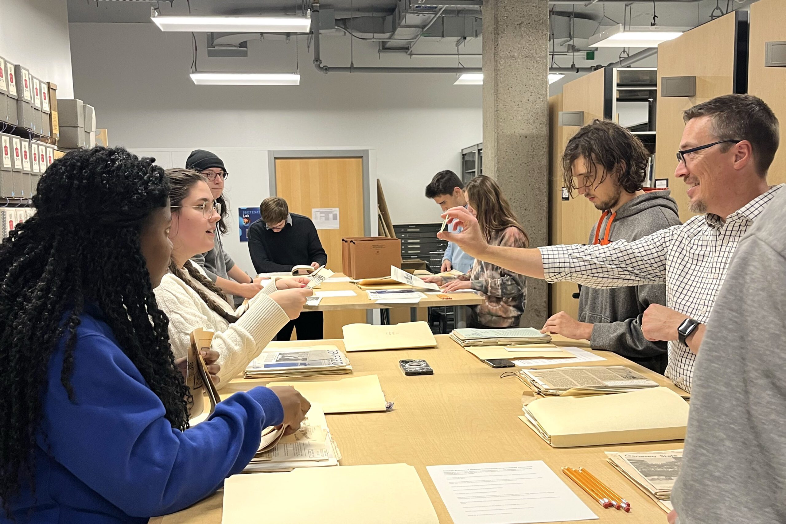 Faculty and students collaborating over archival material.